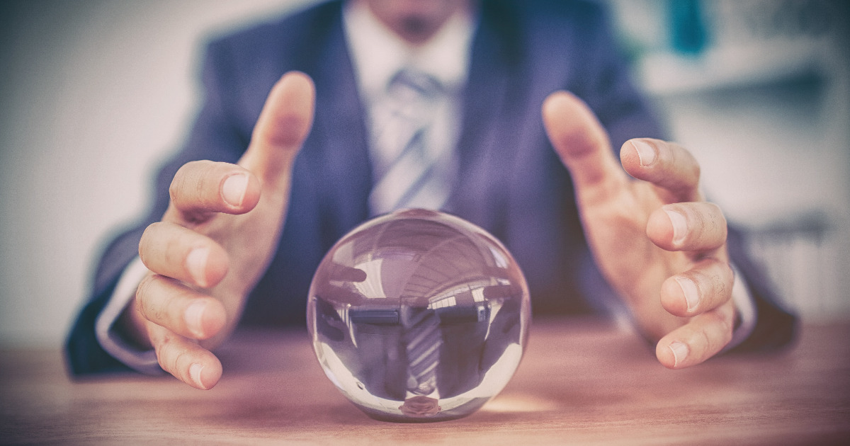 Person in business attire with hands held out near a crystal ball on desk, representing prediction of future data security governance trends, challenges, and requirements